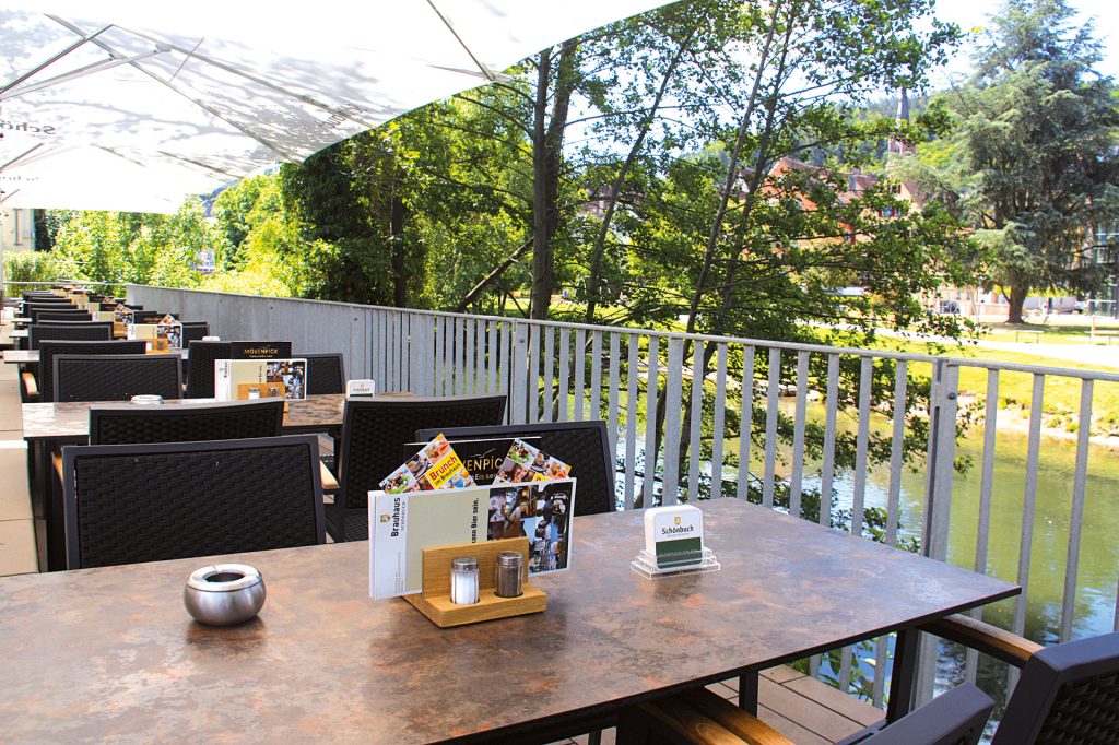 Außenbereich mit Sitzplätzen und Blick ins Grüne im Brauhaus Schönbuch.