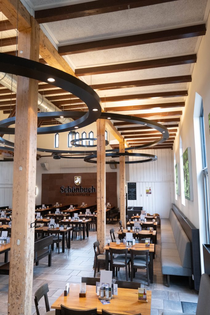 Heller Gastraum mit hohen Decken und rustikaler Einrichtung im Brauhaus Schönbuch.