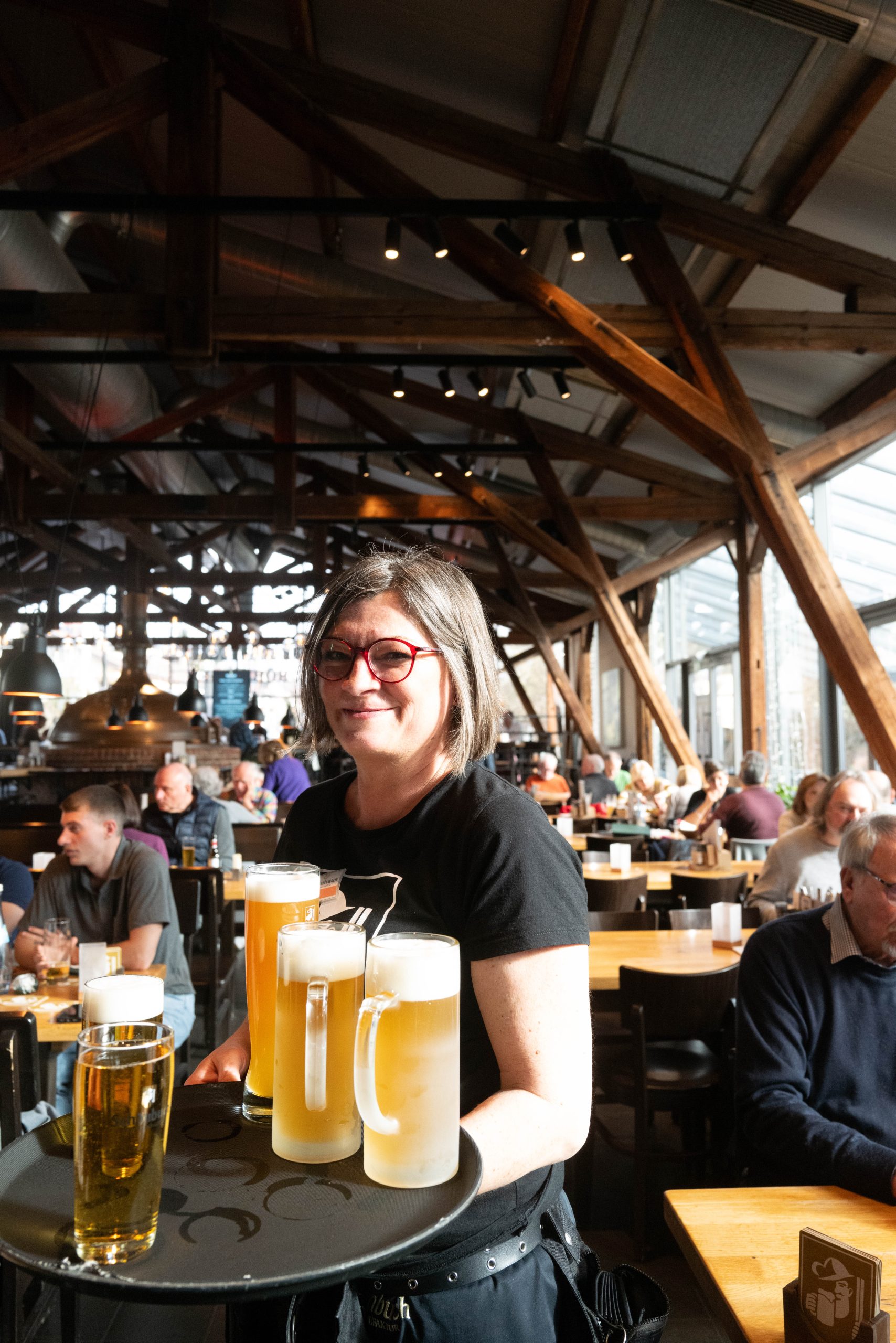 Servicekraft bringt Getränke im Brauhaus Schönbuch an den Tisch.