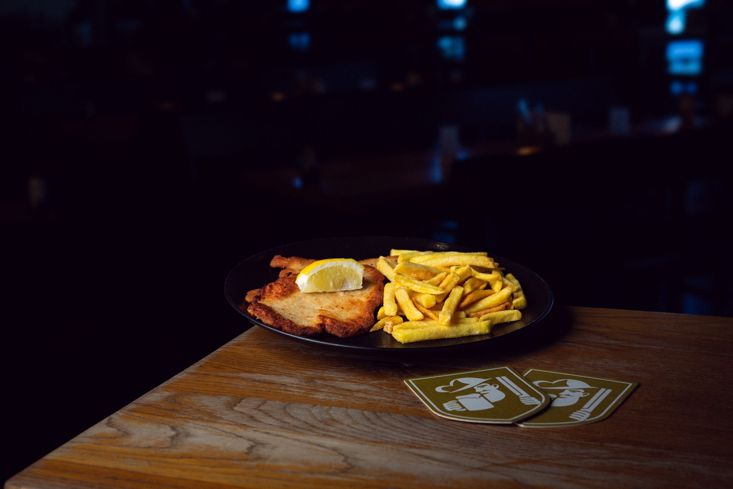 Schnitzel mit Pommes auf einem schwarzem Teller im Brauhaus Schönbuch
